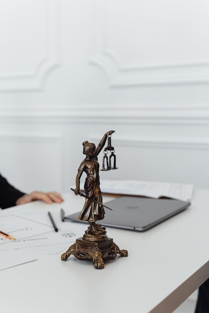 Close-up of Lady Justice statue on a white table in an office setting.
